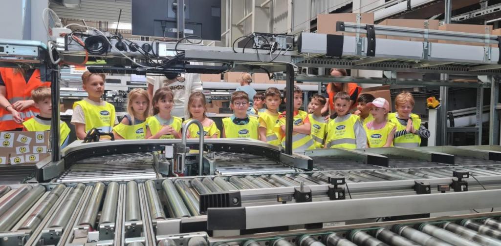 Barbara Baldauf Alle Kinder stehen vor der Arbeitsstation wo die Kisten gepackt werden