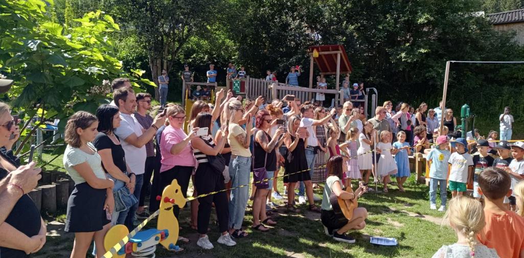Verena Eder Eltern und Verwandte der Schulkinder stehen hinter der Absperrung und filmen die Kinder beim Singen