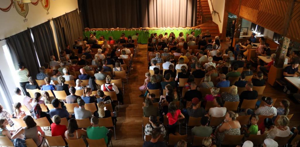 Der Saal des Vereinshaus mit vielen Zuschauern, die in den Stuhlreihen sitzen