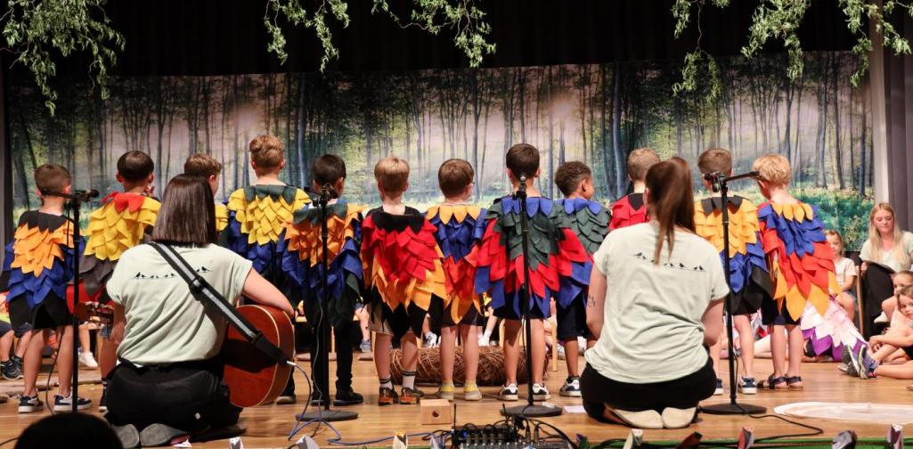 Die dekorierte Bühne mit den Kindern die verkehrt stehen, damit die Flügel der Kostüme gut zu sehen sind