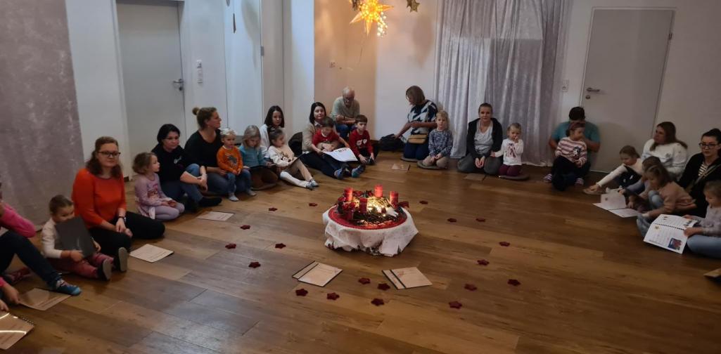 Verena Eder Die Kinder und die Erwachsenen sitzen rund um den Adventkranz