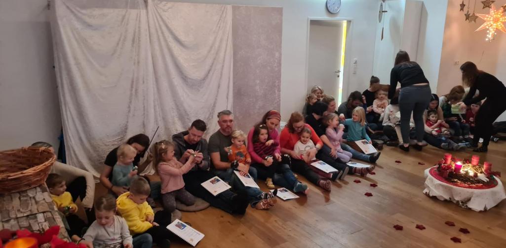 Verena Eder Die Kinder und die Erwachsenen sitzen rund um den Adventkranz