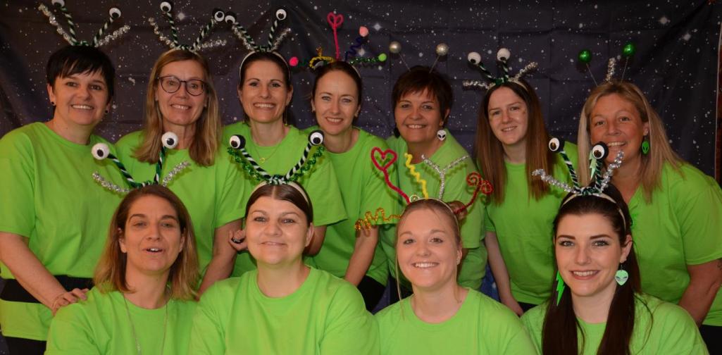 Das Team als Alien verkleidet ; mit grünen T-Shirts und einem Alienkopfschmuck