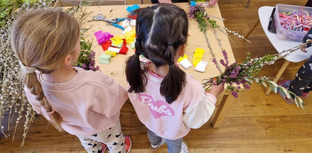 Verena Eder Zwei Kinder wollen ihren Palmbuschen binden. Eine Pollinger Bäuerin hilft dabei