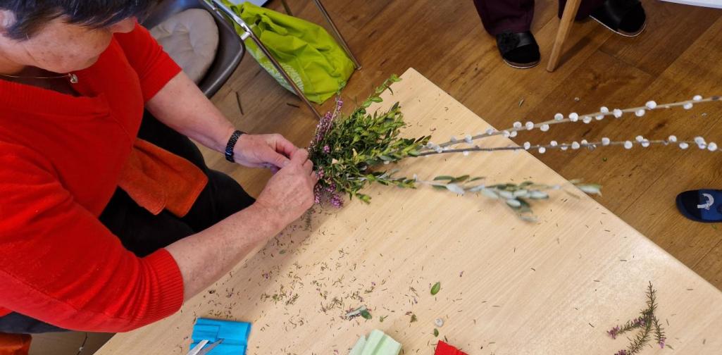 Verena Eder Eine Frau bindet einen Palmbuschen