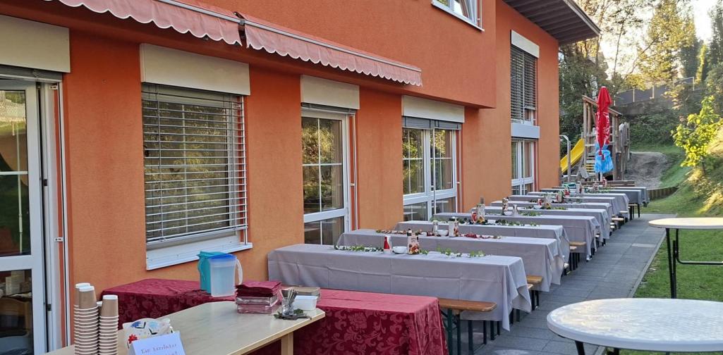 Verena Eder Der Garten mit vielen aufgestellten Bierzeltgarnituren für die Besucher