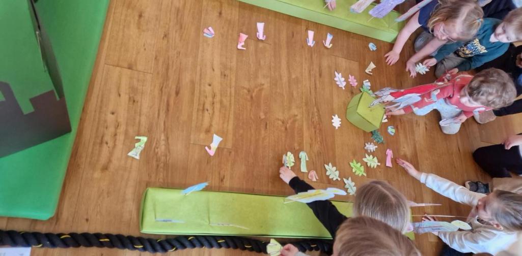 Die Kinder legen die angemalten Kleidungsstücke und Palmblätter in den Weg.