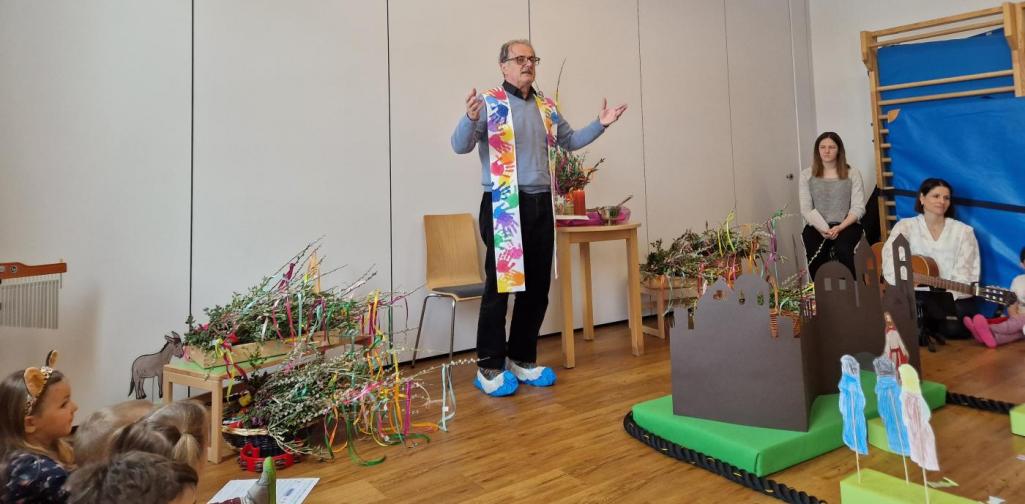 Pfarrer Josef neben den Palmbuschen beim Segnen der Kiner