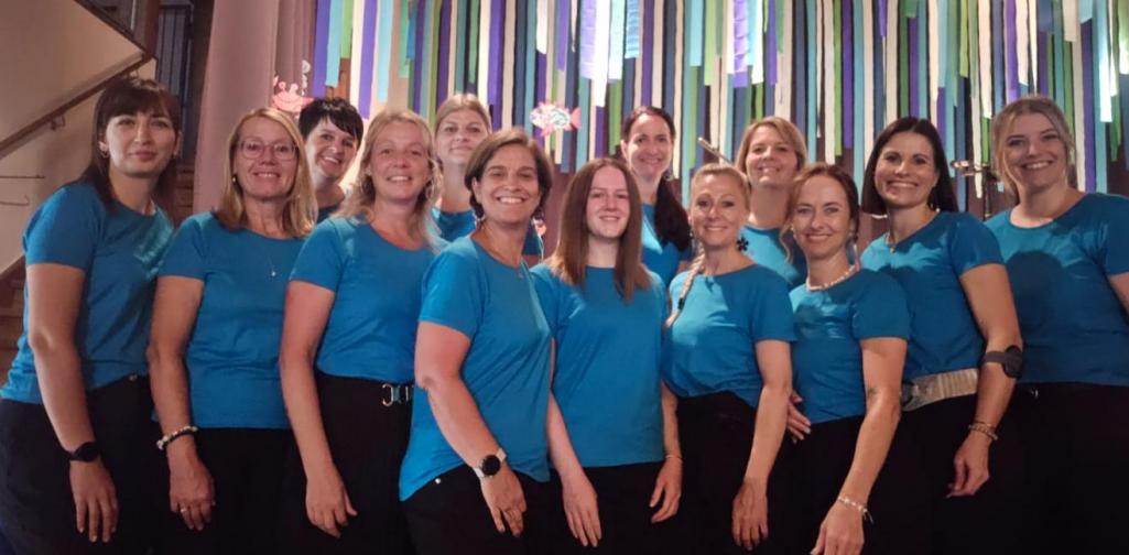 Das Team des Kinderagrten und der Kinderkrippe vor der Bühne. Alle tragen das gleiche blaue T- Shirt