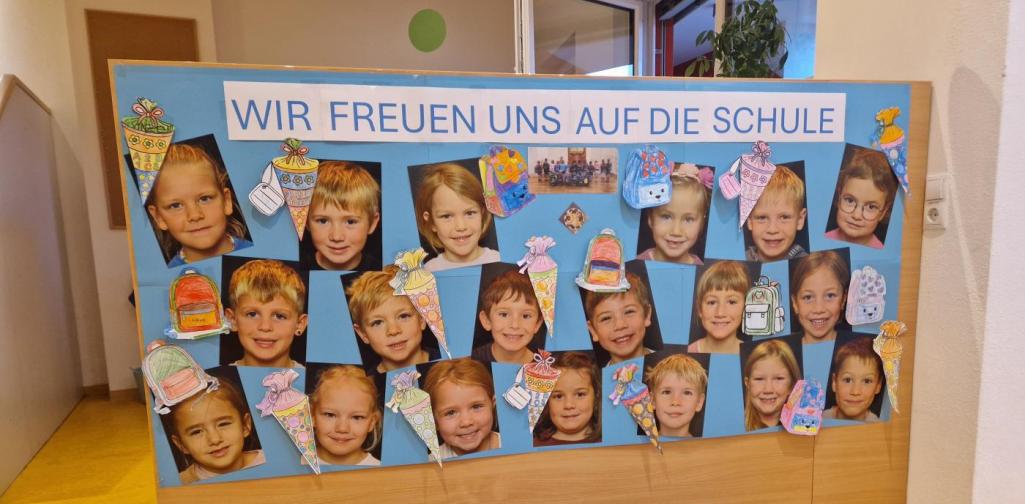 Ein Plakat mit den Portraitfotos der Schulkinder und der Überschrift: Wir freuen uns auf die Schule